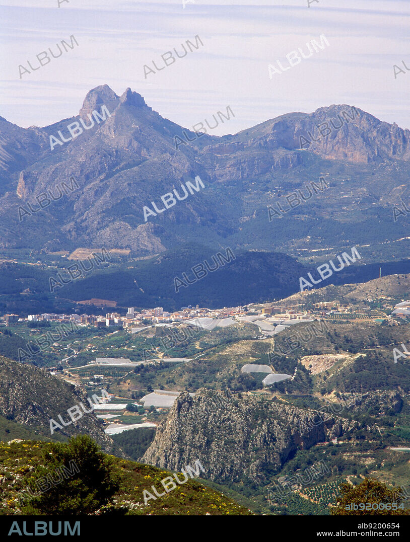 PAISAJE MONTAÑOSO - PUEBLO EN EL VALLE - INVERNADEROS DE NISPEROS  - FOTO AÑOS 90.