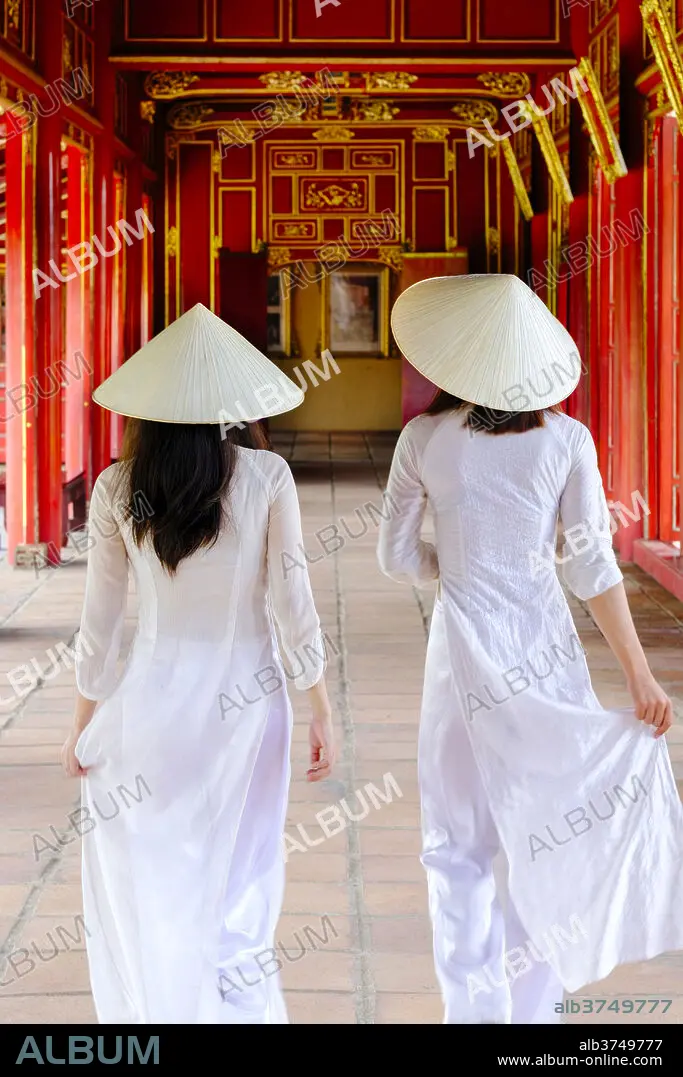 Vietnamese women in traditional Ao Dai dresses and Non La