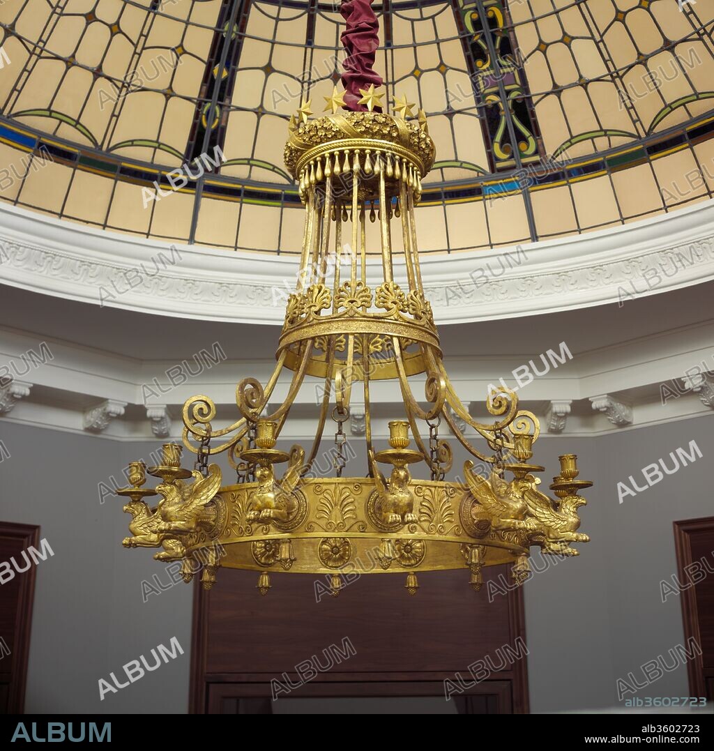 Chandelier. Artist: Thomas Hope (British (born Holland), Amsterdam 1769-1831 London). Dimensions: H. from bottom of pendants to top of stars: 120.6 cm; W. (overall): 108 cm.. Date: ca. 1802.
This chandelier was made after a design by the wealthy banker and patron Thomas Hope, published in his 1807 book entitled Household Furniture and Interior Decoration. The book contains an engraving with a schematic design of the chandelier as well as details of the griffins. Probably created for Hope's London residence, the chandelier as well as other furniture designed by him, were influenced by contemporary French Empire production.