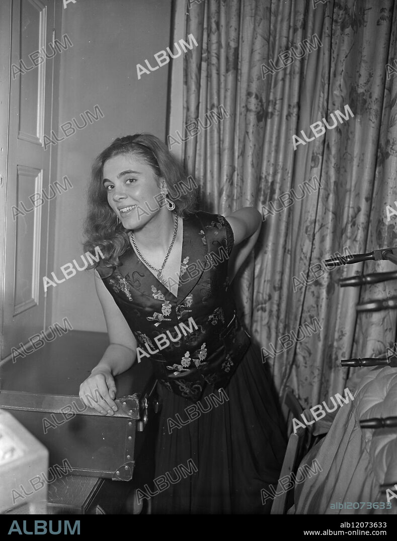 MAYFAIR SOCIALITES DISPLAY THEIR EDWARDIAN WAISTCOATS 19.2.54. Edwardian waistcoats were given an airing at a fashionable party in the West End last night. Mr. Bobbie Owen, a leading young city financier, entertained guests in the Edwardian style at his home at 44 Mount Street, Mayfair. To qualify for entry, guests were asked to wear brocaded waistcoats; many flew from as far afield as the United States to attend the function. I.N.P. PHOTO SHOWS - Miss Stephanides of Greece displays her 'fancy waistcoat' to good advantage. Picture by R. Palmer 74653/MB International News Photos.