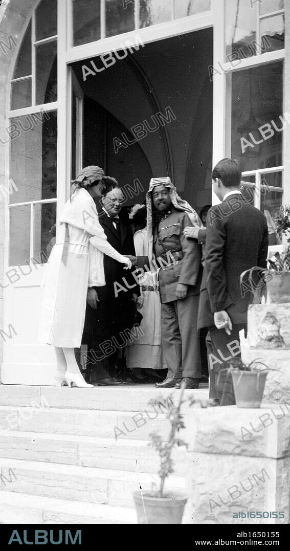 Emir Abdullah of Transjordan on the steps of Government House, Jerusalem, 1921, shaking hands with Mrs Churchill, Winston Churchill standing next to his wife.