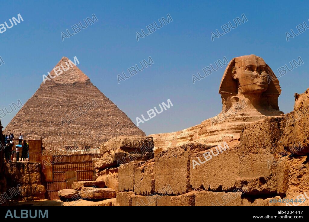 The Great Sphinx of Giza set against the Pyramid of Khufu. limestone statue of a reclining sphinx. a mythical creature with the body of a lion and the head of a human. Facing directly from West to East. it stands on the Giza Plateau on the west bank of the Nile in Giza. Egypt. The face of the Sphinx is generally believed to represent the Pharaoh Khafre. Cut from the bedrock. (approx. 2558–2532 BC).