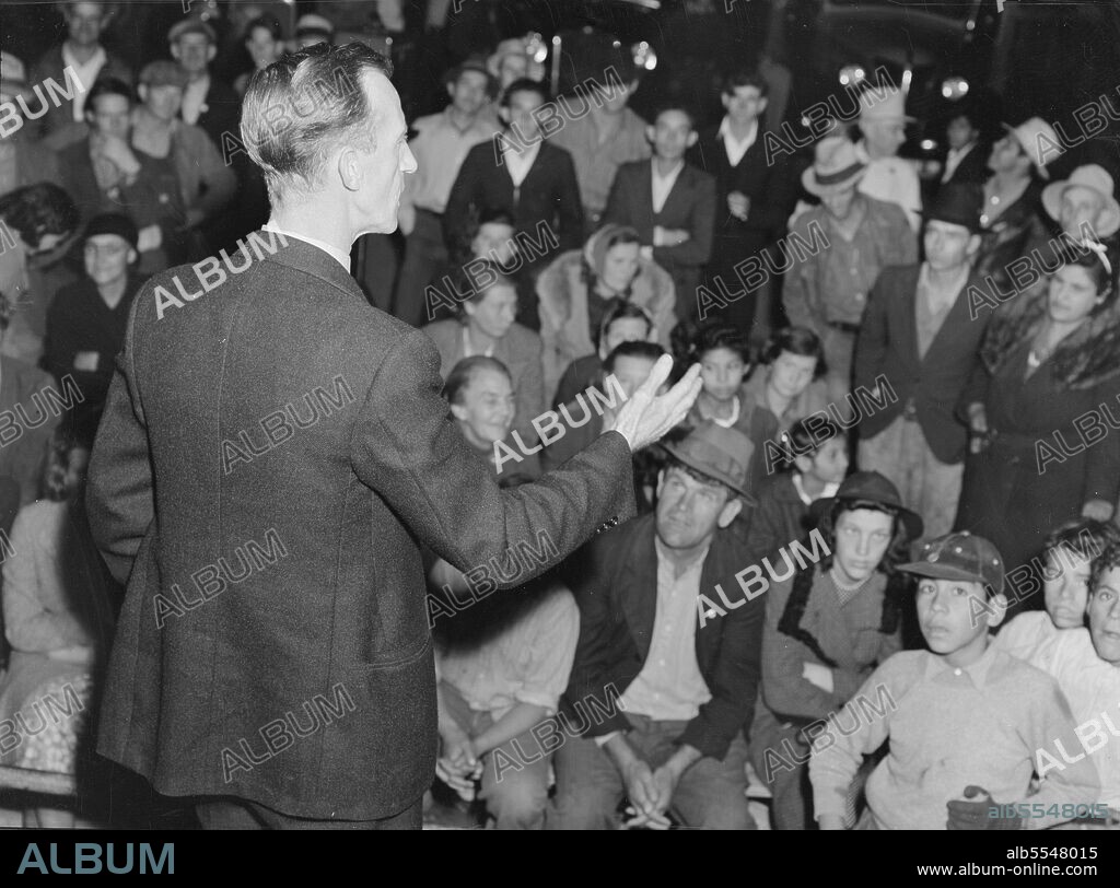 DOROTHEA LANGE. Street meeting at night in Mexican town outside of Shafter, California. Organizer for United Cannery Agricultural Packing and Allied Workers of America (Congress of Industrial Organizations-CIO) talks to mixed crowd. The strike failed.