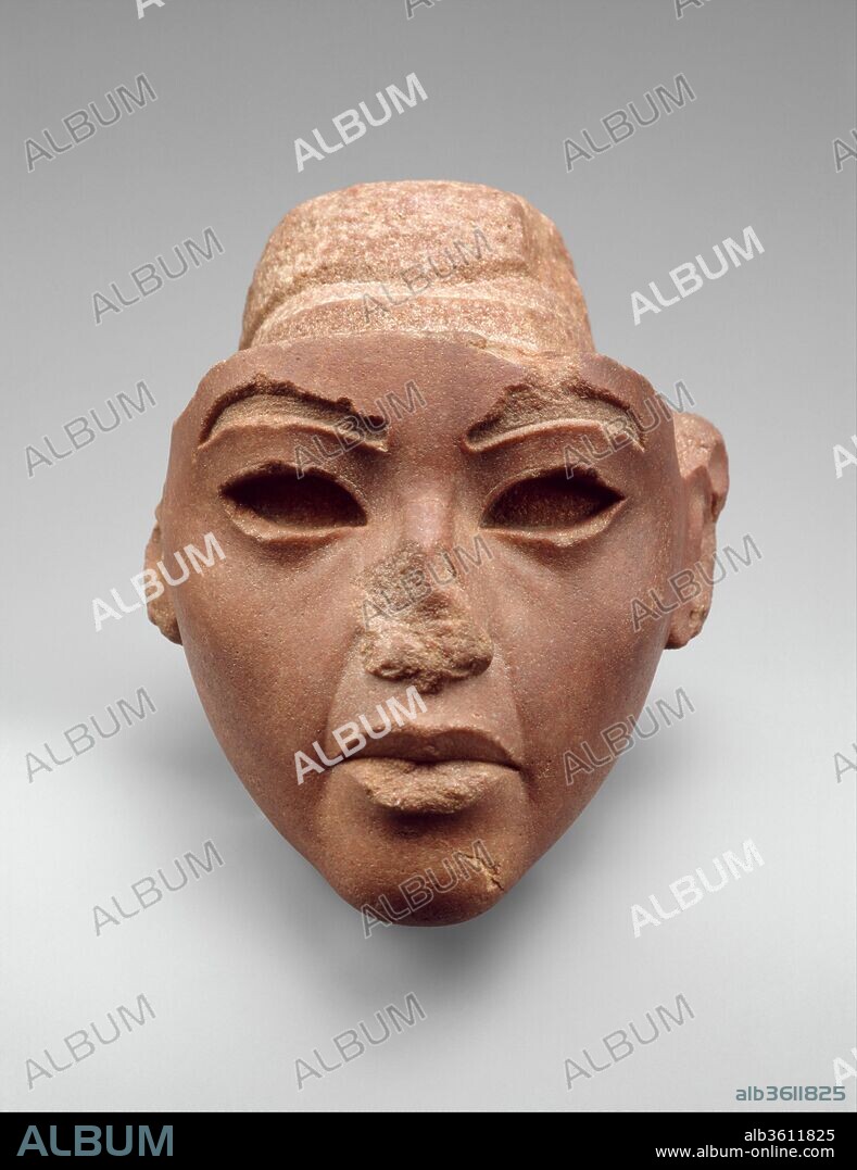 Face from a Composite Statue, probably Queen Tiye. Dimensions: H. 13.3 cm (5 1/4 in.); W. 12.5 cm (4 15/16 in.); D. 12.4 cm (4 7/8 in.)
H. of face 11 cm (4 5/16 in.). Dynasty: Dynasty 18. Reign: reign of Amenhotep III-Akhenaten. Date: ca. 1353-1336 B.C..
This quartzite head once belonged to a composite statue made of several different materials.  Based on the color of the stone (red being the conventional color for men), the owner was originally identified as Akhenaten.  However, the subject seems to have worn the standard tripartite wig, which frames the face with two thick hanks of hair while a third section hangs down the back.  This wig and the very close similarity of the face to known images of Akhenaten's mother, Queen Tiye, make it virtually certain that she is represented here.
The sensitive modeling of the face is typical of the workshop of the sculptor Thutmose at site of Amarna.  The existence of gypsum plaster casts excavated in Thutmose's studio suggests that this may have been part of a group statue depicting Akhenaten with his parents, Tiye, and Amenhotep III.