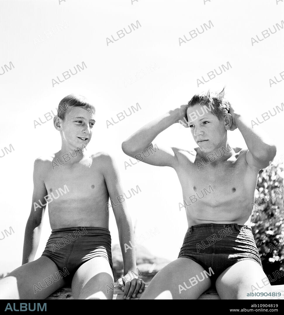 Two young teen boys in swimsuits relaxing after a swim, Rupert, Idaho, USA, Russell Lee, U.S. Farm Security Administration, July 1942.