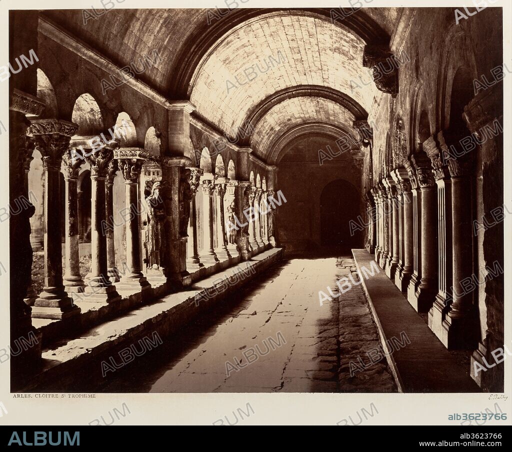 EDOUARD BALDUS. Arles, Cloitre St. Trophime. Artist: Édouard Baldus (French, born Prussia, 1813-1889). Dimensions: Image: 33.2 x 42.5 cm (13 1/16 x 16 3/4 in.)
Mount: 46 x 60.5 cm (18 1/8 x 23 13/16 in.). Date: ca. 1861.
The twelfth-century cloister of the Church of Saint-Trophîme in Arles, noted for its richly carved capitals, ranks among the most important examples of French medieval architecture, and was among the sites that Baldus first photographed on his 1851 "mission héliographique." In the context of the "Paris-Lyon-Méditerranée" album, this picture's tunneling perspective and the repetition of arches link the famous cloister to the achievements of Second Empire engineers--to the railroad tunnels and arched viaducts that are presented in a similar fashion elsewhere in the volume.
Proper exposure of a scene that included both shadowed interior and sunlit exterior presented a difficult task. Careful scrutiny of the print reveals that Baldus used thin tissue overlays on the most transparent sections of the glass negative so as not to lose all detail in the darkest parts of the print. In addition, light washes of watercolor or ink were used to give tone to some of the lightest areas and to define the cloister colonnade.