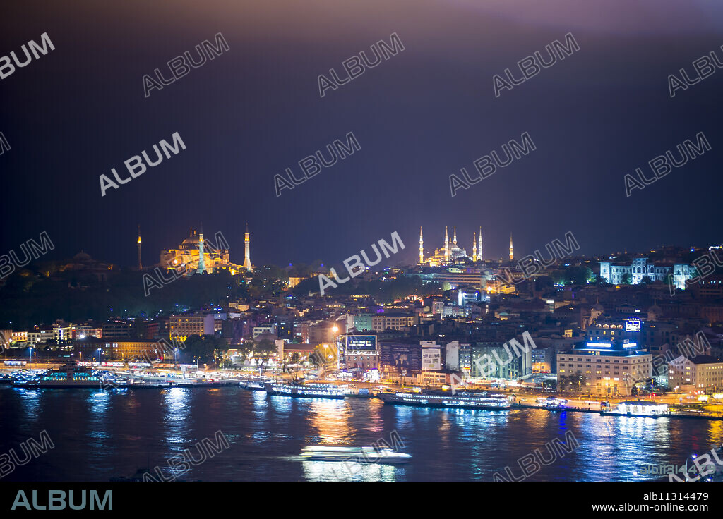 Blue Mosque (Sultan Ahmet Mosque) and Hagia Sophia (Aya Sofya) at night seen from The Galata Tower across the Bosphorus Strait, Istanbul, Turkey, Europe.