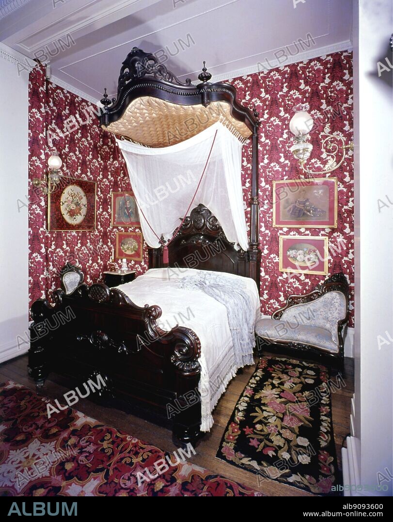 New Orleans bedroom 1850-60. Bed by Mallard. Love seat upholstered by Belter. Wallpaper repro of mid 19th century design. From the American Museum, Bath. ©TopFoto.