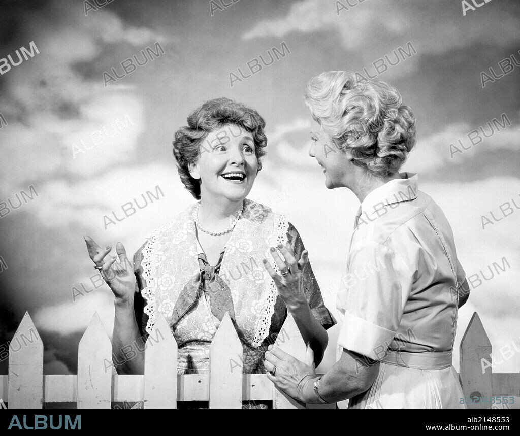 Two mature women talking outdoors.