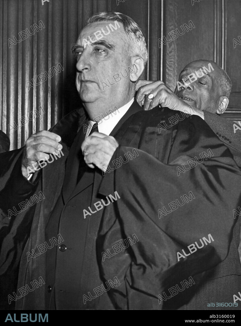 Washington, D.C.: October 7, 1946. The new Chief Justice of the Supreme Court, Fred Vinson, is helped from his robes by attendant Robert Marshall after completing his first day as presiding judge of the nation's highest court.