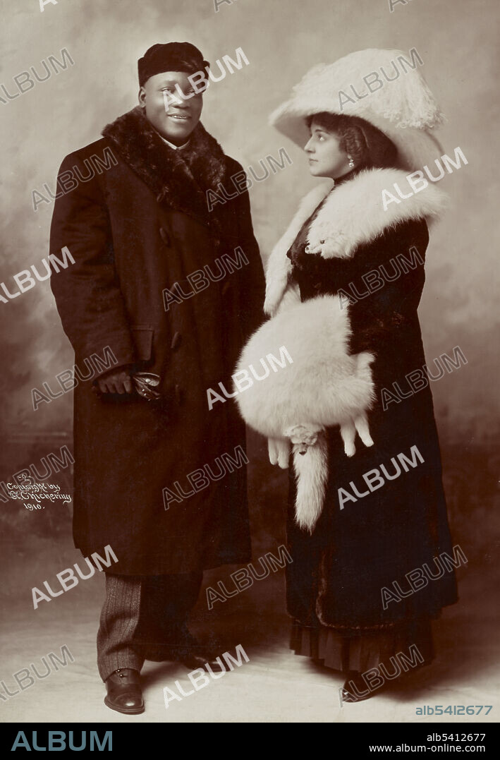 Jack Johnson and his wife Etta wearing winter coats Etta Terry Duryea, a Brooklyn socialite and former wife of Clarence Duryea, were married in 1911. Prone to depression, her condition worsened because of Johnson's abuse and infidelity. She committed suicide in September 1912, shooting herself. John Arthur Johnson (March 31, 1878 - June 10, 1946) was the first African-American world heavyweight boxing champion (1908-15). He had a unique fighting style, which was not customary to boxing during this time. He would fight defensively, waiting for his opponents to tire out. He would continuously dodge their punches, and quickly strike back with a blow of his own. He often made his fights look effortless, but when pushed he could also display some powerful moves, and punches. He was an early example of the celebrity athlete in the modern era, appearing regularly in the press and later on radio and in motion pictures. On June 10, 1946, he died in a car crash after racing angrily from a diner that refused to serve him. He was 68 years old. During his boxing career, he fought 114 fights, winning 80 matches, 45 by knockouts. He was inducted into the Boxing Hall of Fame in 1954, and is on the roster of both the International Boxing Hall of Fame and the World Boxing Hall of Fame. No photographer credited, January 27, 1910.