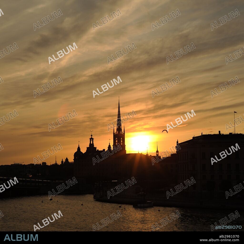 PUESTA DE SOL con la silueta de la torre de la Iglesia Riddarholmen. Barrio Antiguo. Estocolmo. Suecia.
