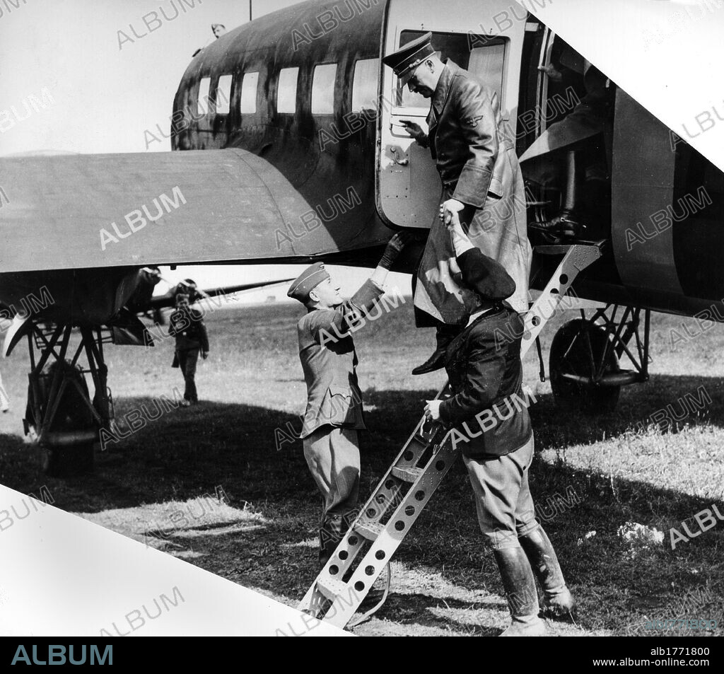 Adolf Hitler descends from the plane followed by Hans von Mackensen. German Chancellor Adolf Hitler, with ambassador Hans von Mackensen, descends from a Foche-Wulf Condor four-engined aircraft in which he has flown behind the southern lines together with Benito Mussolini. August 1941.