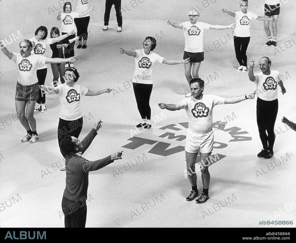 STOCKHOLM 1975.. Orig. bildtext... TRÄNA MED TV 1975. Hans Ekman, Stellan Norrlander, Kerstin Kind, Folke Mossfeldt, Bernt Bernholm, Gun Hägglund. Anm. Publ i RiR 4/75 TVDiv L22 S Norrlander f d chef Filmarkivet (Tevearkivet). F Mossfeldt svensk gymnastikdirektör, ledde TV-serien Träna med TV på 1960-talet. B Bernholm 1914-2006, svensk medicinjournalist, verksam vid Expressen, var med och startade tidningen 1944. G Hägglund 1932, Sveriges första kvinnliga nyhetsuppläsare, medverkade bl a i tv-programmet Träna med TV. Armar Ben Rörelser Träningskläder Gymnastikskor CD492 persons: GUN HÄGGLUND;BERNT BERNHOLM;FOLKE MOSSFELDT;KERSTIN KIND;STELLAN NORRLANDER;HANS EKMAN sites: SVERIGE;STOCKHOLM.