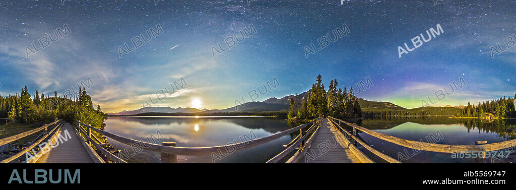 A 360 degree night panorama lit by moonlight, taken from the boardwalk out to Pyramid Island on Pyramid Lake in Jasper National Park, Alberta, Canada. To the southwest, the waxing gibbous moon is setting. At right of centre, the Boardwalk leads to Pyramid Island itself, with Pyramid Mountain behind it. Right of the island is the Big Dipper. To the right of the image, to the northeast, theres a weak aurora display. The Milky Way is faintly visible in the moonlit sky overhead.