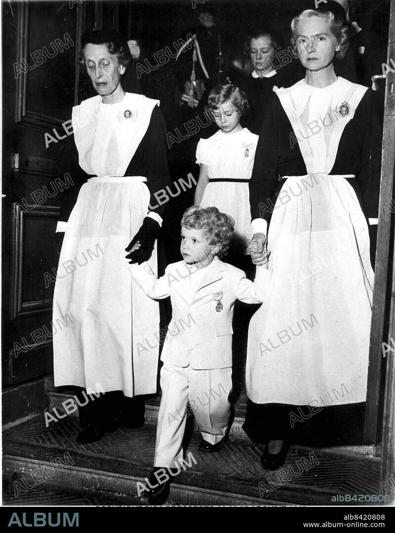 FILE 1950. ENGCAP: CROWN PRINCE CARL GUSTAF AT THE TIME OF HIS GRANDFATHER'S DEATH. LEFT; GRAND MOTHER QUEEN LOUISE, RIGHT; MOTHER PRINCESS SIBYLLA.. Kronprinsen med drottning Louise och prinsessan Sibylla vid farfars fars, Gustaf V:s begravning i november 1950. Klädd i ljus kostym. Håller farmor drottning Louise (t.v.) och modern prinsessan Sibylla i handen.. Foto: Scanpix Code: 20360. ***.