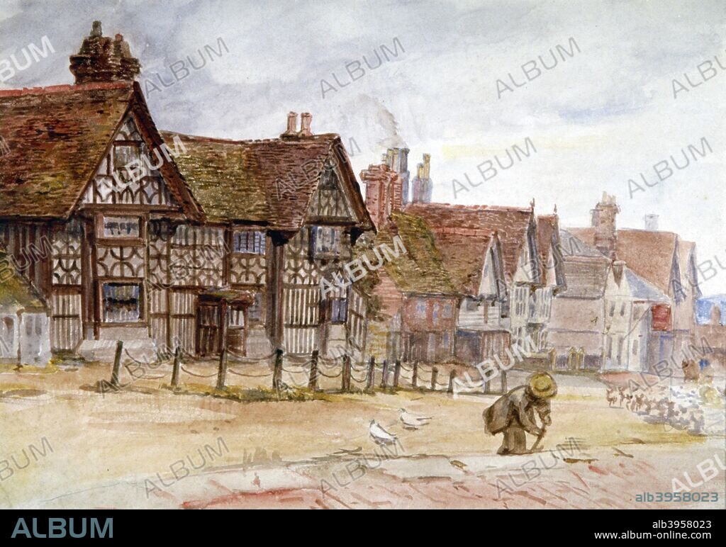 'Village Street with Tudor Houses', c1864-1930. Scene with pigeons in the street and a figure digging.