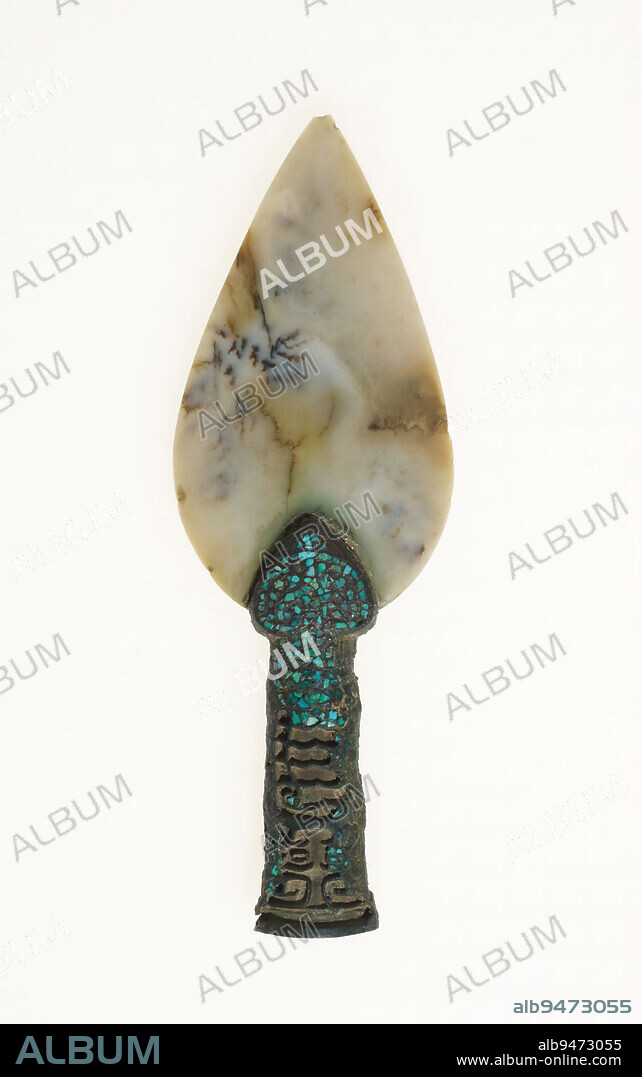 Ceremonial mao spear head, 1600-1046 BCE, 6 9/16 × 2 1/4 × 11/16 in., 0.2 lb. (16.67 × 5.72 × 1.75 cm, 0.1 kg)1 × 11/16 in. (2.54 × 1.75 cm) (object part, bottom opening), Greyish white jade with variations of bluish and brown clouds, bronze with green crystal inlay, China, Late Shang dynasty, A bronze spear head fastened to a long pole would have served as a weapon in hand-to-hand combat. This example, composed of a jade blade and a bronze hilt, was far more rare and would only have had a ceremonial function. The jade spear has a central ridge creating a beveled surface resembling a real spear blade. The surface of the bronze hilt is cast with taotie animal masks inset with green stones. Among the findings at the Shang capital, Anyang, bronze spear heads were common, whereas spears made of bronze and jade, like this one, were rare.
