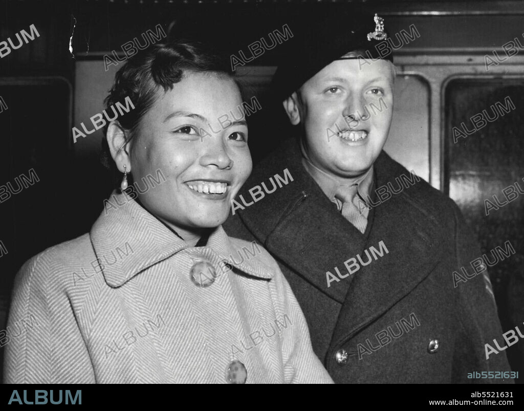 "Goddess Of The Moon" Come To London -- Ho Lai Sheum (Beautiful Goddess of the Moon) arrives at St. Pancras Station with her English husband, Sergeant Allan Pickford of Southport, Lancashire, who met her a birthday party in Hong Kong last year. They arrived at Tilsbury earlier in the liner Corfu from Singapore.And She's a good cook, too - A Goddess in a tweed coat and fur-lined boots arrived in London yesterday. Her name is Ho Lai-Sheum, which in Chinese means Beautiful Goddess of the Moon, but she is more usually known now as Mrs. Alan Pickford, wife of a Royal Army Pay Corps sergeant. January 17, 1955.