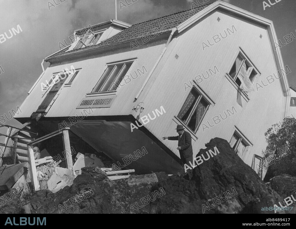 ©SCANPIX SWEDEN, 1950-09-29.. Surtekatastrofen - lutande hus.. Katastrofen i Surte norr om Göteborg, där ett jordskred har gjort stor förödelse. På bilden ser vi en man beskåda förödelsen på sin fastighet.. Foto: Scanpix. Code: 20360.
