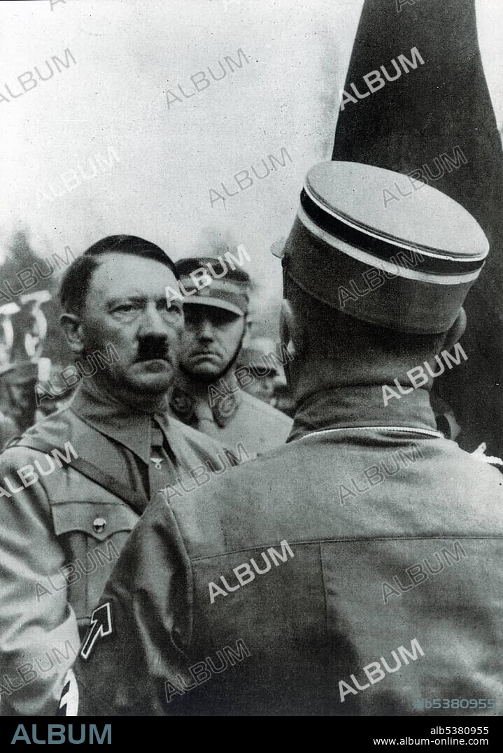 Adolf Hitler "consecrating" new flags with the Blutfahne blood flag, behind him chief of staff Viktor Lutze, historical photo between 1933-1943.