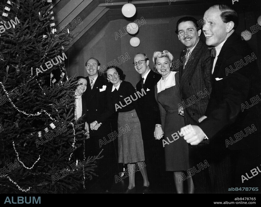 ARKIV 1943-12-11. Artister och skådespelare fr. v. Anna-Lisa Beude, Lars Krantz, Ulla Billquist, Thore Ehrling, Sylva Åkesson, Stig Järrel och Gösta Jonsson dansar runt julgranen i kabareten Den glada karusellen 1943-12-11.. Foto: Sören Hoffman / SVT / Kod: 5600. RiR personmapp, Billquist, Ulla.