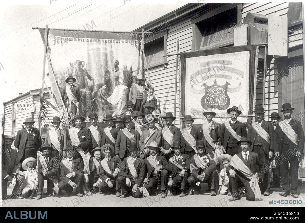Photograph - Operative Bricklayers Society Eight Hour Day Delegates, Victoria, circa 1920s, Black and white photograph of the Operative Bricklayers Society's Eight Hour Day delegates in front of union banners circa 1920s. This image was reproduced from an original held by Victorian State Building Trades' Union, Bricklayers' Division. Action taken by stonemasons on 21 April 1856 led to the establishment of the Eight Hour Day, with the government agreeing that workers employed on public.