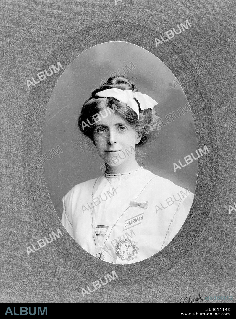 Annie Kenney, organiser, June 1908. Born in Lancashire, Annie Kenney started work aged 10, attending school for half the day and working at the mill for the other half, later becoming active in trade unionism. She and Christabel Pankhurst committed the first militant act at the Free Trade Hall in Manchester in October 1905. She moved to London to become a paid organiser, operating mostly in the West Country, frequently appearing on suffragette processions dressed in her mill clothes, clogs and shawl. Annie was utterly loyal to Emmeline and Christabel, the only working-class woman to become part of the senior hierarchy of the Women's Social and Political Union, becoming deputy in 1912. She served four prison sentences, and her three sisters, Jennie, Jessie and Nell, and a brother were all involved in the campaign. She is dressed for Women's Sunday on 21 June 1908. She wears a purple, white and green Votes for Women badge, made of cotton, and her badge of office as Chairman of one of the twenty platforms in Hyde Park, from which speeches were made.