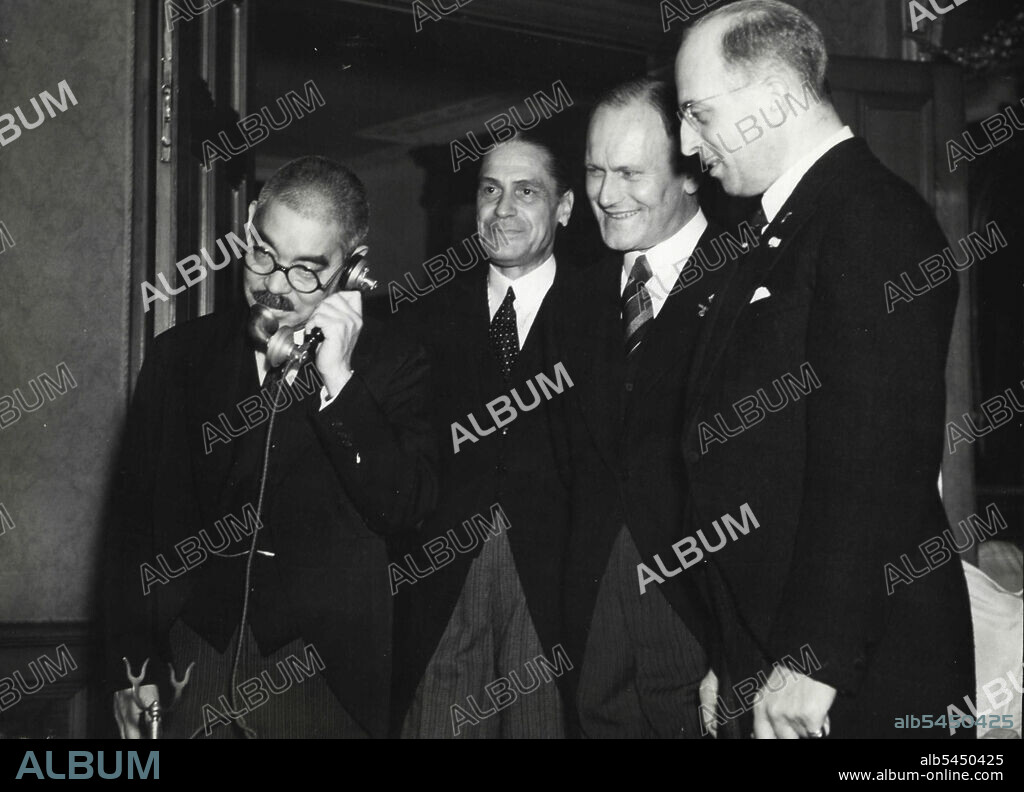 Japan, Germany And Italy Form Mutual Assistance Pact - Foreign minister Yosuke Matsuoka in a telephone conversation wilt Berlin soon after the signing of the German-Italian-Japanese mutual assistance pact there at Chancellor Hitler's chancellery. He is exchanging salutations with German Foreign Minister Joachim Von Ribbentrop and Italian Foreign Minister Galeazzo Ciano. Shown beside him are, left to right: Italian Ambassador Mario Indelli, German Ambassador Eugen Ott, and German minister-at-large Stahmer, who played an important role in the conclusion of the tripartite alliance. October 28, 1940. (Photo by Japan Photo Library, Inc.).