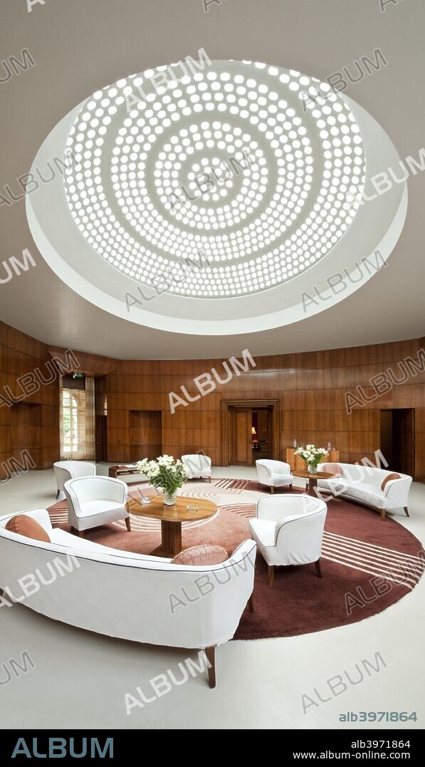 Entrance hall of Eltham Palace, Greenwich, London, 2010. Interior view showing the glass domed roof, Engstromer furniture and Dorn rug. Eltham was a royal palace, but by the early 20th century it was partly ruined. In the 1930s the Courtauld family used the architects Seely & Paget to restore and extend the historic buildings to create a family home. The entrance hall was designed by Swedish designer Rolf Engstromer.