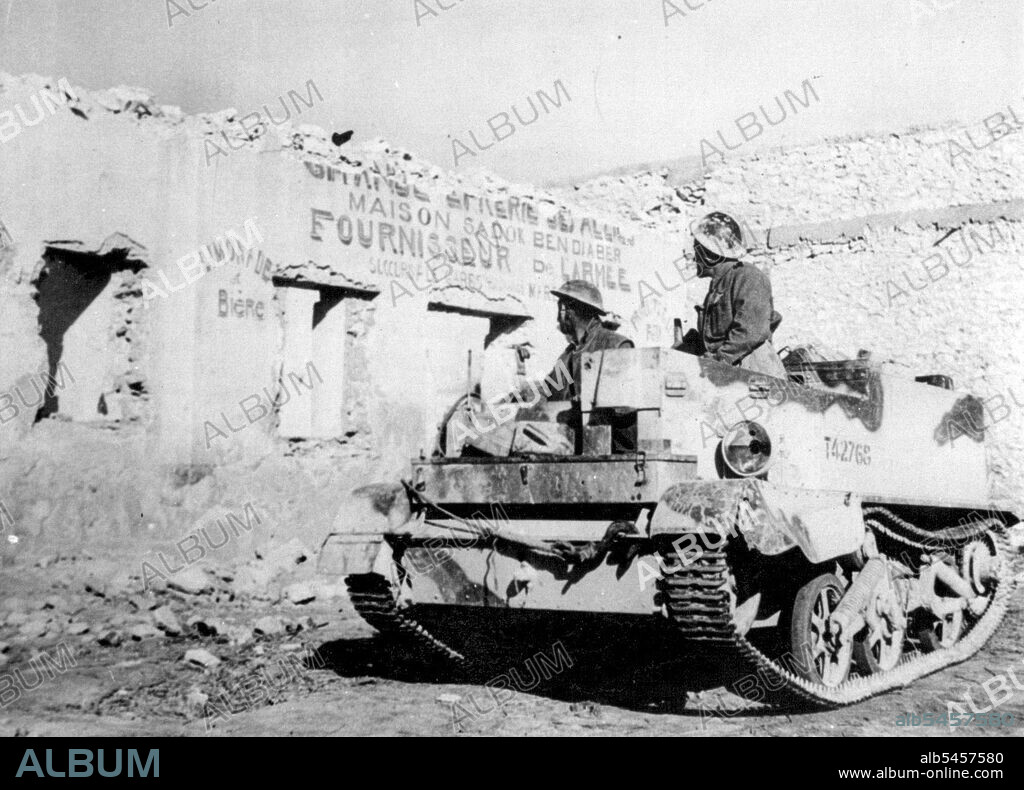 Scars Of Mareth Line Fighting -- In a Desert-Worn tank, British Tommies who played roles in the Victory of the Mareth line look over damage done by the fighting to one of the few shops at Mereth. April 14, 1943. (Photo by Associated Press Photo).