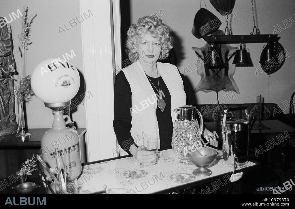 German singer, dancer and actress Evelyn Kuenneke behind the counter of her private bar at Hamburg, Germany around 1984.