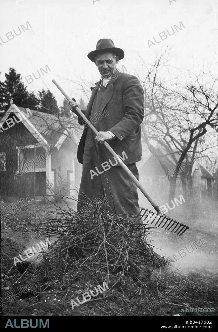 Stockholm 1944 . Stora Mossens koloniträdgård. Hissmontör Oskar Westerberg med kratta och eld. Foto: Dagens Nyheter / DN / TT / Kod: 192. ** SvD OUT **.