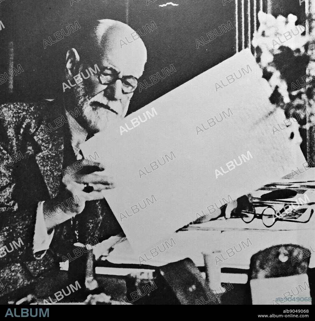 Freud in his study at 20 Maresfield Gardens, reading his manuscript for 'Moses and Monotheism' 1939. Sigmund Freud (1856 - 23 September 1939); Austrian neurologist and the founder of psychoanalysis. Martha Bernays (1861 - 1951).