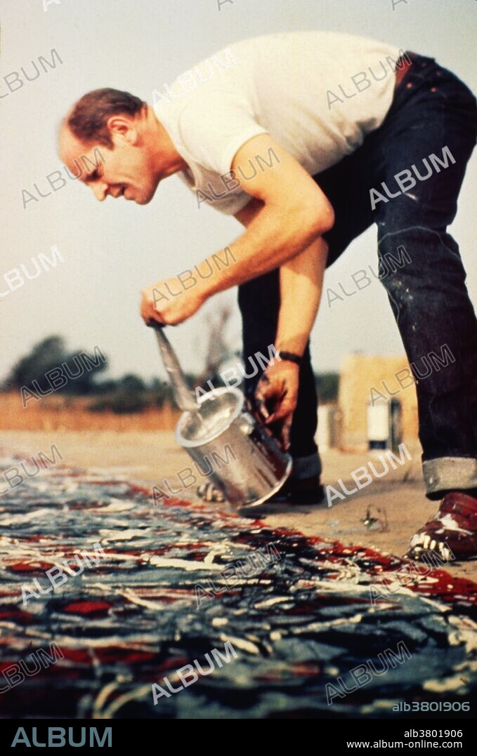 Jackson Pollock (1912 - 1956) was an American abstract expressionist at work at his studio in 1950. Pollock is seen here painting one of his famous splatter paintings. Long Island, NY.