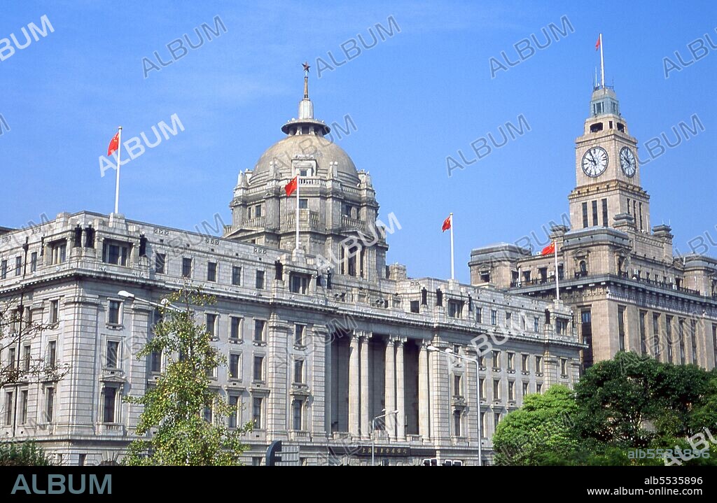 The Bund (Chinese: Wàitan) is an area of Huangpu District in central Shanghai. The area centres on a section of Zhongshan Road (East-1 Zhongshan Road) within the former Shanghai International Settlement, which runs along the western bank of the Huangpu River, facing Pudong, in the eastern part of Huangpu District. The Bund usually refers to the buildings and wharves on this section of the road, as well as some adjacent areas. Shanghai began life as a fishing village, and later as a port receiving goods carried down the Yangzi River. From 1842 onwards, in the aftermath of the first Opium War, the British opened a ‘concession’ in Shanghai where drug dealers and other traders could operate undisturbed. French, Italians, Germans, Americans and Japanese all followed. By the 1920s and 1930s, Shanghai was a boom town and an international byword for dissipation. When the Communists won power in 1949, they transformed Shanghai into a model of the Revolution.