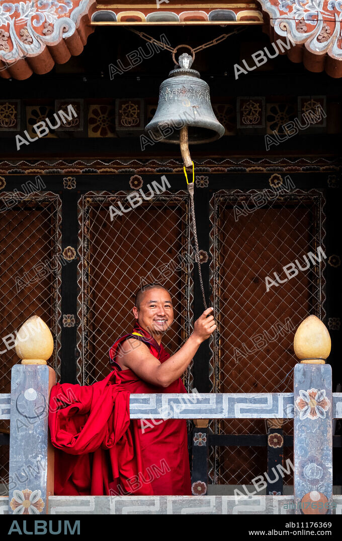 Buddhist monk ringing prayer bell, Trongsa Dzong, Trongsa, Bhutan, Asia.