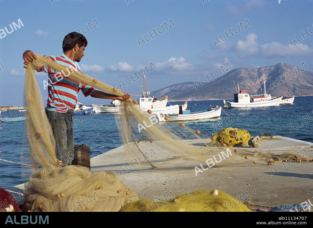 Fisherman sorting his nets, harbour of island of Koufounissia, Lesser Cyclades, Greek Islands, Greece, Europe.