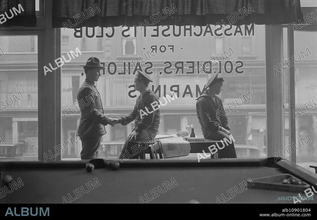 BAIN NEWS SERVICE. Window of Mass. Hdqrs., between 1917 and c1920. Soldiers and sailors sitting in front of a window reading "Massachusetts Club for Soldiers, Sailor, and Marines.".