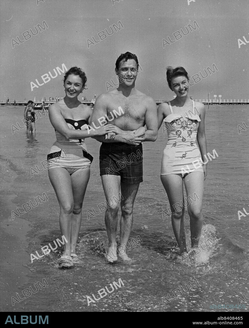 Film Festival Fun -- A happy trio enjoying themselves in The Lido at Vanice, where they are attending the Film Festival, are (left to right) Italian actress Irene Genna, Richard Todd and 16-year-old Janette Scott, when film "Now and Forever" is being shown during the Festival.A delegation from the Associated British film studios at Elstree is now in Venice for the 1955 International Film Festival taking place there. The party includes stars Richard Gray, together with director Mario Zampi. In their "off duty" time, the stars are taking full advantage of the festival and are enjoying themselves in the famous Venice Lido. September 01, 1955. (Photo by Fox Photos).