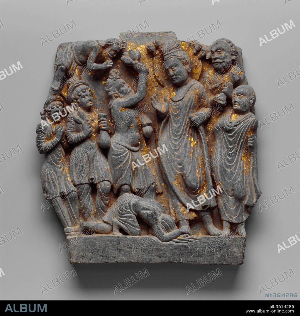 Dipankara Jataka (The Story of the Ascetic Megha and the Buddha Dipankara). Culture: Pakistan (ancient region of Gandhara, Swat Valley). Dimensions: H. 8 3/4 in. (22.2 cm); W. 8 3/8 in. (21.3 cm); D. 1 1/2 in. (3.8 cm). Date: ca. 2nd century.
In this panel the ascetic Megha (the Buddha Shakyamuni in a past life) appears three times: first, standing before the Buddha Dipankara throwing flowers; second, prostrate before the Buddha spreading his matted locks over mud; and third, flying in the upper left of the panel in a gesture of veneration.
This story is the critical beginning of the Gandharan narrative cycle, as the Buddha Dipankara predicts that in a future life Megha will reach enlightenment and become the Buddha Shakyamuni.