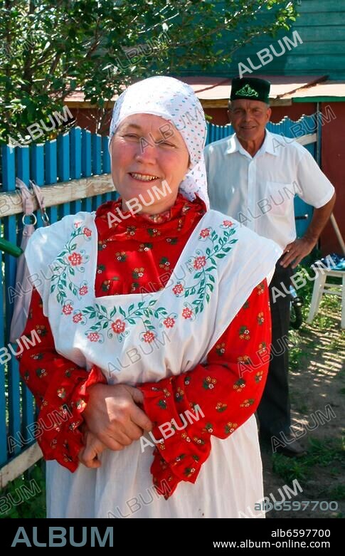 Russland, autonome Republik Tatarstan, Tatarendorf Kora Hodscha; alte Bäuerin in Nationaltracht, im Hintergrund ihr Gatte.