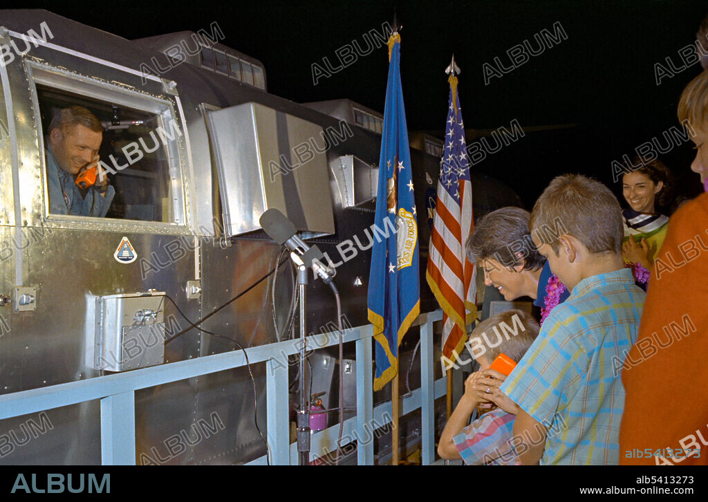 Neil A. Armstrong, commander of the Apollo 11 flight, greets his son Mark, on telephone intercom system, while his wife Jan and another son Eric look on. Armstrong had just arrived in early morning with the Mobile Quarantine Facility (MQF) at Ellington Air Force Base. Armstrong and fellow astronauts will remain in the MQF until arrival and confinement in the Crew Reception Area (CRA) of the Lunar Receiving Laboratory (LRL) at the Manned Spacecraft Center (MSC). Quarantine period will end on August 11, 1969. Apollo 11 was the spaceflight that landed the first two people on the Moon. Commander Neil Armstrong and lunar module pilot Buzz Aldrin landed the Apollo Lunar Module Eagle on July 20, 1969. Armstrong became the first person to step onto the lunar surface six hours later on July 21; Aldrin joined him 19 minutes later. They spent about two hours together outside the spacecraft, and collected 47.5 pounds of lunar material to bring back to Earth. Command module pilot Michael Collins flew the command module Columbia alone in lunar orbit while they were on the Moon's surface. Armstrong and Aldrin spent 21.5 hours on the lunar surface before rejoining Columbia in lunar orbit.