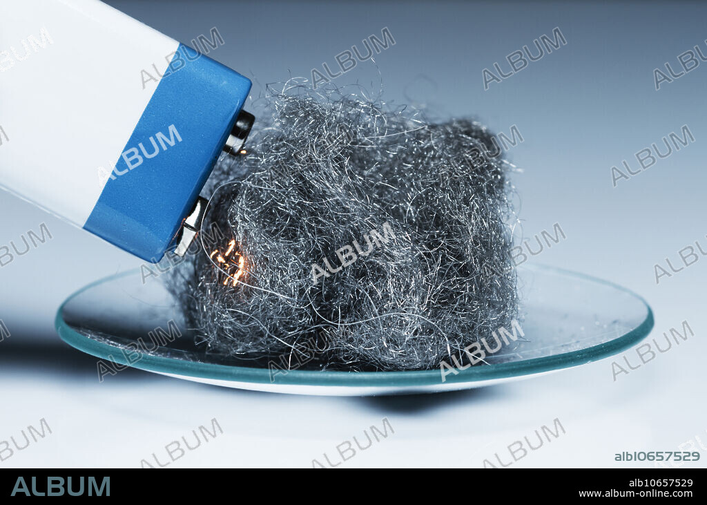 Steel wool burning, 1 of 3. Steel wool is made of very thin bundled steel filaments (25 micron thickness here). The filaments have a very large surface area to volume ratio. When terminals of a 9V battery are brushed against steel wool, the filaments conduct current and complete the circuit. Due to Ohmic heating, their temperature is increased enough for them to start burning. Steel wool burns in air (20% oxygen by volume) only gently. In this oxidation reaction a mixture of different iron oxides is produced (FeO, Fe2O3, Fe3O4), depending on how much oxygen gets to a particular bit of iron.