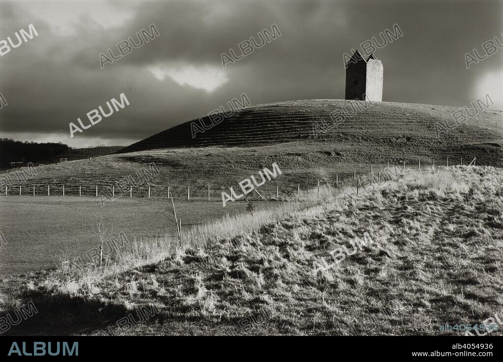 FAY GODWIN. Ruined stone tower on hilltop in grassy landscape. Monochrome. Source: FG5714-4-7.