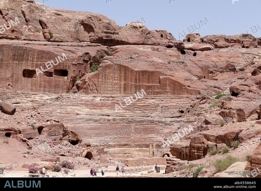 first century AD Nabatean theatre in Petra, Jordan. Substantial part of the theatre was carved out of solid rock, while the scaena and exterior wall were constructed. The theatre's auditorium consists of three horizontal sections of seats separated by passageways and seven stairways to ascend. The theatre could accommodate a number of approximately 8500 people. The theatre was built in the cultural and political apex of the Nabatean kingdom under Aretas IV (9 BC-40 AD), In 1812, the city of Petra and Al-Khazneh was rediscovered by Swiss explorer Johann Ludwig Burckhardt.