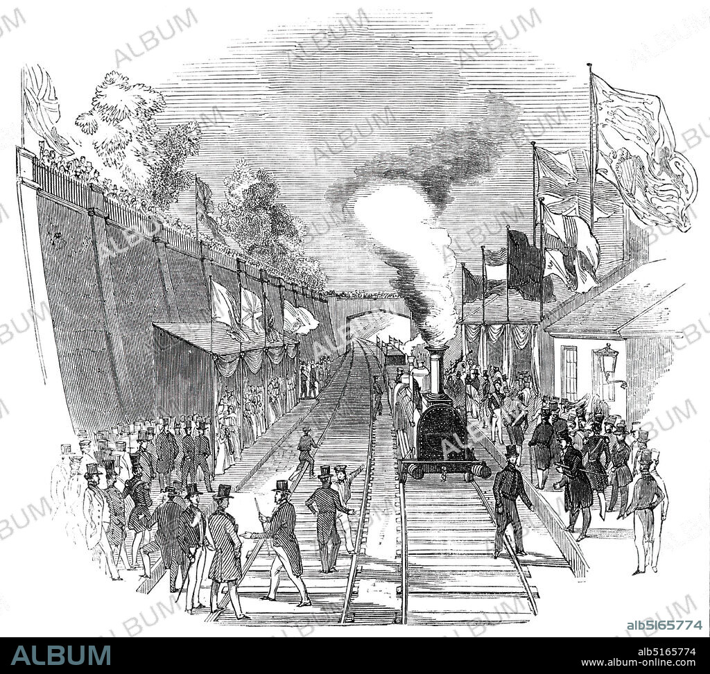 Her Majesty's return - Weedon Station, 1844. Queen Victoria and Prince Albert return to London by train after their stay at Burghley House. 'At the town and station of Weedon great numbers of people had collected. The military...lined the road, and there was a guard of honour...under the command of Captain Gordon. The Marquis of Exeter, who had arrived previously, and Sir Henry Dryden, the high sheriff of the county, were at the station to receive her Majesty. At a quarter past two the approach of her Majesty to the station was announced by the elevation of the Royal standard, and in a few minutes more the Royal party entered the station...On the departure of the Queen and Prince Albert, the Prince shook hands with the Marquis of Exeter, and the train started, amidst the cheers of the people, at five minutes to three o'clock'. From "Illustrated London News", 1844, Vol V.