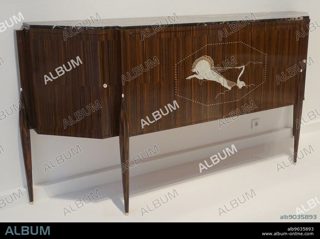 Desserte dite meuble au char Sideboard with an ivory inlay 1921. By Jacques-Emile Ruhlmann. Émile-Jacques Ruhlmann (28 August 1879 15 November 1933), his first names often seen reversed as Jacques-Émile, was a renowned French designer of furniture and interiors, epitomising for many the glamour of the French Art Deco style of the 1920s.