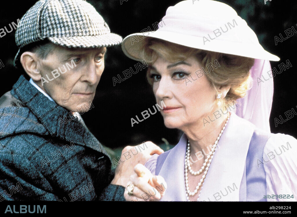 ANNE BAXTER and PETER CUSHING in SHERLOCK HOLMES AND THE MASKS OF DEATH, 1984 (THE MASKS OF DEATH), directed by ROY WARD BAKER. Copyright LORIMAR PRODUCTIONS.