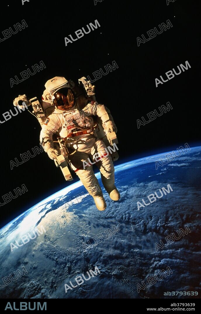 Spacewalk. Astronaut Bruce McCandless floats free above the Earth in his manned maneuvering unit (MMU). This is a composite image showing the Earth photographed during another shuttle mission. Bruce McCandless conducted this spacewalk on February 7, 1984, during shuttle mission 41B. McCandless helped design the MMU and was the first person to fly it, thus becoming the first "human satellite" in orbit around the Earth. The MMU is propelled by nitrogen thrusters controlled by the astronaut's hands. Because no umbilical cord attaches the astronaut to the spacecraft, it gives much greater mobility than was available to previous spacewalkers. Storm clouds are seen over the Earth.